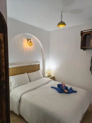 a bedroom with a bed with a teddy bear on it at Riad Dar Barka Privatisé 3 chambres in Marrakech