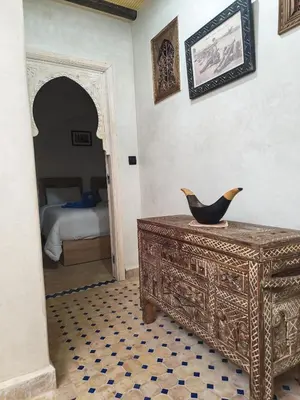 a room with a wooden dresser with a bird on it at Riad Dar Barka Privatisé 3 chambres in Marrakech