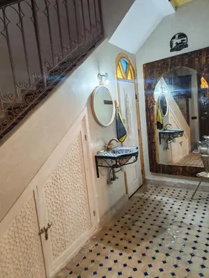 a bathroom with a sink and two mirrors on the wall at Riad Dar Barka Privatisé 3 chambres in Marrakech