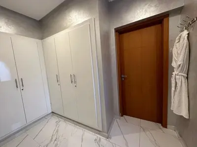 a bathroom with white cabinets and a wooden door at Villa à la palmeraie in Marrakech
