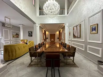 a dining room with a long table and a chandelier at Villa à la palmeraie in Marrakech