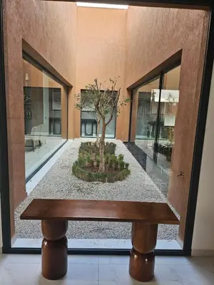 a bench with a tree in the middle of a building at Villa Nobu - Architect-designed villa with pool in Douar Bellouk