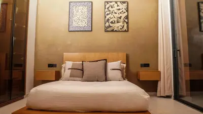 a bedroom with a bed with two pictures on the wall at Villa Nobu - Architect-designed villa with pool in Douar Bellouk