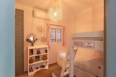 a small bedroom with a bunk bed and a window at Riad Cosy in Marrakech