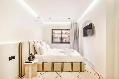 a white bedroom with a bed and a window at Sweet Clarity Swimming pool and Parking in Marrakech