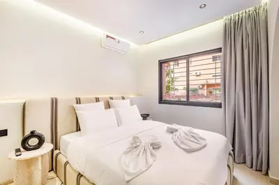 a bedroom with a large white bed with a window at Sweet Clarity Swimming pool and Parking in Marrakech