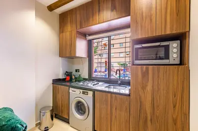 a kitchen with a washing machine and a microwave at Sweet Clarity Swimming pool and Parking in Marrakech