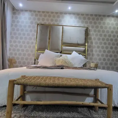a bedroom with a bed with a bench at the end of it at Villa Maison Dar Sukar in El Caïd Omar
