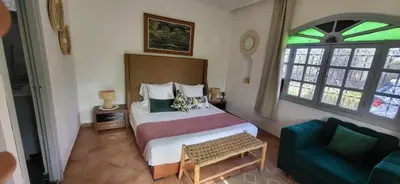 a bedroom with a bed and a blue couch at Villa Maison Dar Sukar in El Caïd Omar