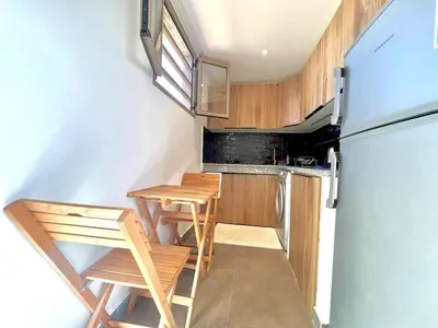 a small kitchen with a table and a refrigerator at Lovely studio 4th floor No Elevator in El Gouassem