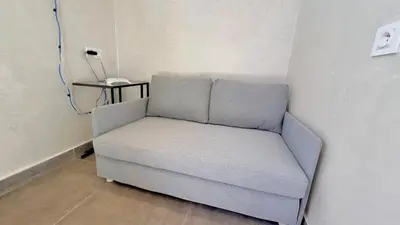 a couch sitting in a corner of a room at Lovely studio 4th floor No Elevator in El Gouassem
