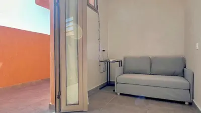 a room with a chair and a mirror at Lovely studio 4th floor No Elevator in El Gouassem