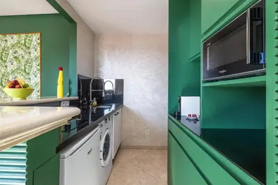 a green kitchen with a sink and a dishwasher at Charming 1-BR with Terrace, AC, Parking-City Center in Marrakech