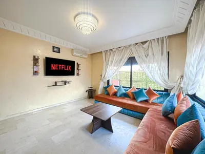 a living room with a couch and a tv at Le Cosy Urbain - Proche centre, Parking & Balcon in Marrakech