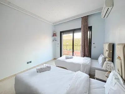 a room with two beds and a window at Le Cosy Urbain - Proche centre, Parking & Balcon in Marrakech