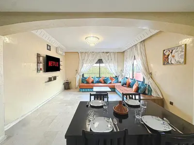 a living room with a table and a couch at Le Cosy Urbain - Proche centre, Parking & Balcon in Marrakech