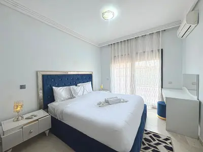 a bedroom with a large bed and a window at Le Cosy Urbain - Proche centre, Parking & Balcon in Marrakech