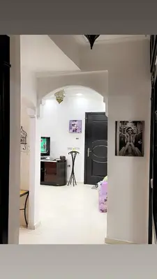 a living room with a black door and a white tile floor at Spacious 2BR with Parking & Local Life & Centra in Marrakech