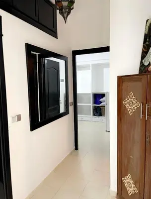 a hallway with a door and a mirror on the wall at Spacious 2BR with Parking & Local Life & Centra in Marrakech