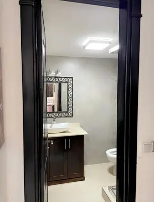 a bathroom with a sink and a mirror and a toilet at Spacious 2BR with Parking & Local Life & Centra in Marrakech