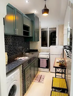 a kitchen with green cabinets and a dishwasher at Spacious 2BR with Parking & Local Life & Centra in Marrakech