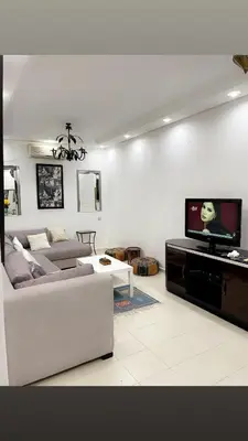 a living room with a couch and a tv at Spacious 2BR with Parking & Local Life & Centra in Marrakech