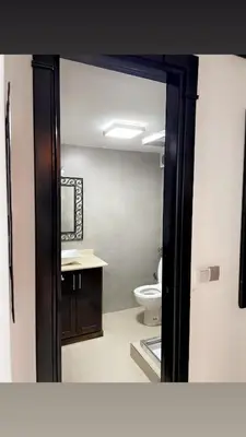 a bathroom with a toilet and a mirror at Spacious 2BR with Parking & Local Life & Centra in Marrakech
