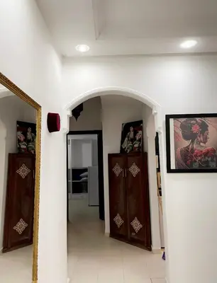 a hallway with two wooden cabinets and a mirror at Spacious 2BR with Parking & Local Life & Centra in Marrakech