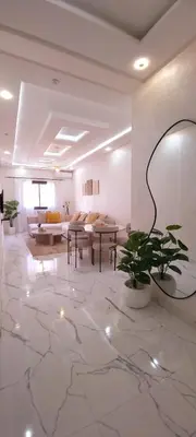 a living room with tables and couches and a plant at Moderne appart NEUF Proche Aéroport et Gueliz in Marrakech