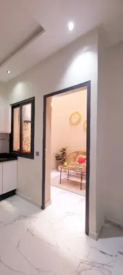 a living room with a door leading into a kitchen at Moderne appart NEUF Proche Aéroport et Gueliz in Marrakech