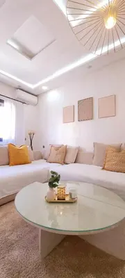 a living room with a white couch and a table at Moderne appart NEUF Proche Aéroport et Gueliz in Marrakech