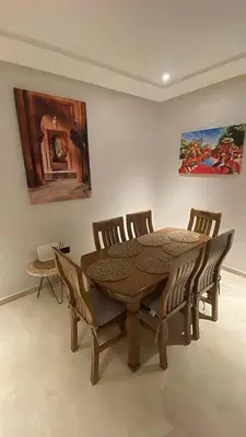 a dining room with a wooden table and chairs at Beautiful Apartment in Guéliz Pools & Jacuzzi in Marrakech