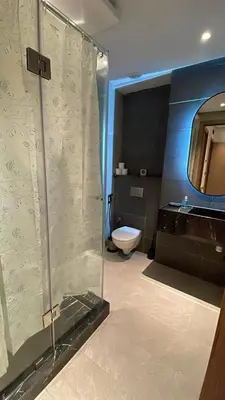 a bathroom with a glass shower and a toilet at Beautiful Apartment in Guéliz Pools & Jacuzzi in Marrakech