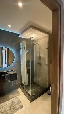 a bathroom with a shower with a glass enclosure at Beautiful Apartment in Guéliz Pools & Jacuzzi in Marrakech