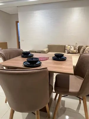 a dining room with a wooden table and chairs at Appartement coup de coeur in Marrakech