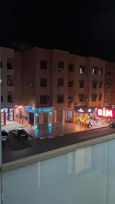 a view of a building at night with a parking lot at Appartement coup de coeur in Marrakech