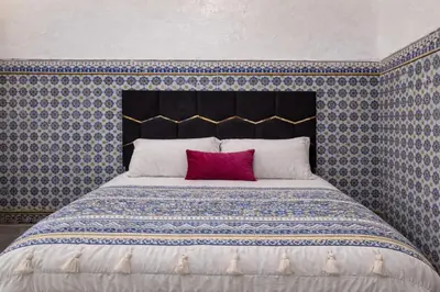 a bedroom with a large bed with a red pillow at Riad Le Sultana in Marrakech