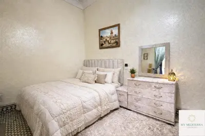 a bedroom with a bed with a dresser and a mirror at Riad Le Sultana in Marrakech