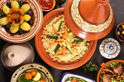 a table with plates of food and bowls of food at Riad Le Sultana in Marrakech