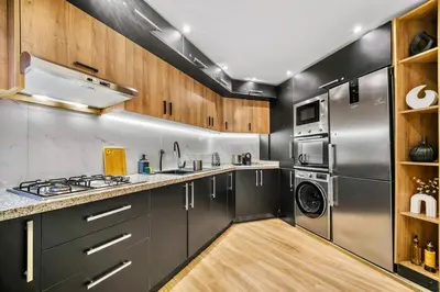 a kitchen with stainless steel appliances and wooden cabinets at Downtown Cozy Apartment with Panoramic View in Marrakech