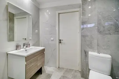 a bathroom with a sink and a toilet and a mirror at Downtown Cozy Apartment with Panoramic View in Marrakech