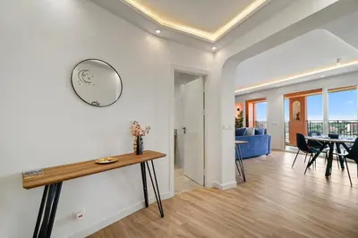 a living room and dining room with a clock on the wall at Downtown Cozy Apartment with Panoramic View in Marrakech