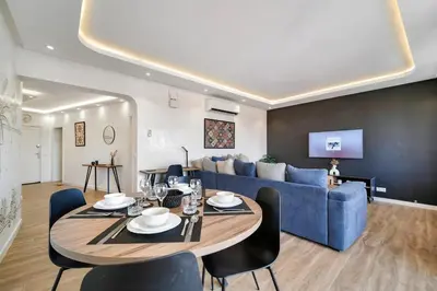 a living room with a table and a blue couch at Downtown Cozy Apartment with Panoramic View in Marrakech