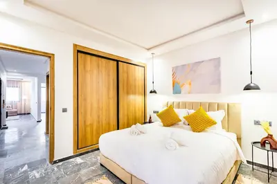a bedroom with a large white bed with yellow pillows at Urban, New 2 BR Apartment in Marrakech