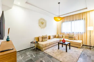 a living room with a couch and a tv at Urban, New 2 BR Apartment in Marrakech