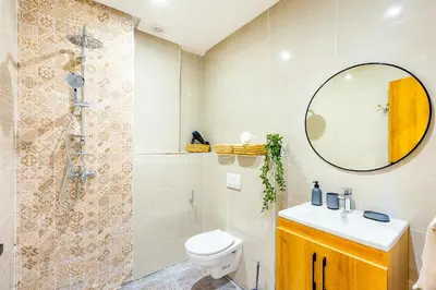 a bathroom with a toilet and a shower and a mirror at Urban, New 2 BR Apartment in Marrakech