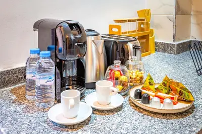 a counter with a coffee maker and cups and food at Urban, New 2 BR Apartment in Marrakech