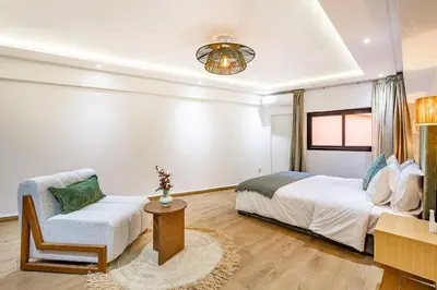 a bedroom with a bed and a chair at 10 min from Stadium AFCON Green Table Loft in Marrakech