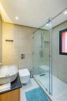 a bathroom with a glass shower and a toilet at 10 min from Stadium AFCON Green Table Loft in Marrakech