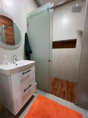 a bathroom with a sink and a shower with a mirror at cozy and spacious apartment in Marrakech